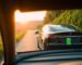 Tesla car with lush scenery and battery icon.