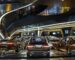 Futuristic diner interior with cars and glowing screens.